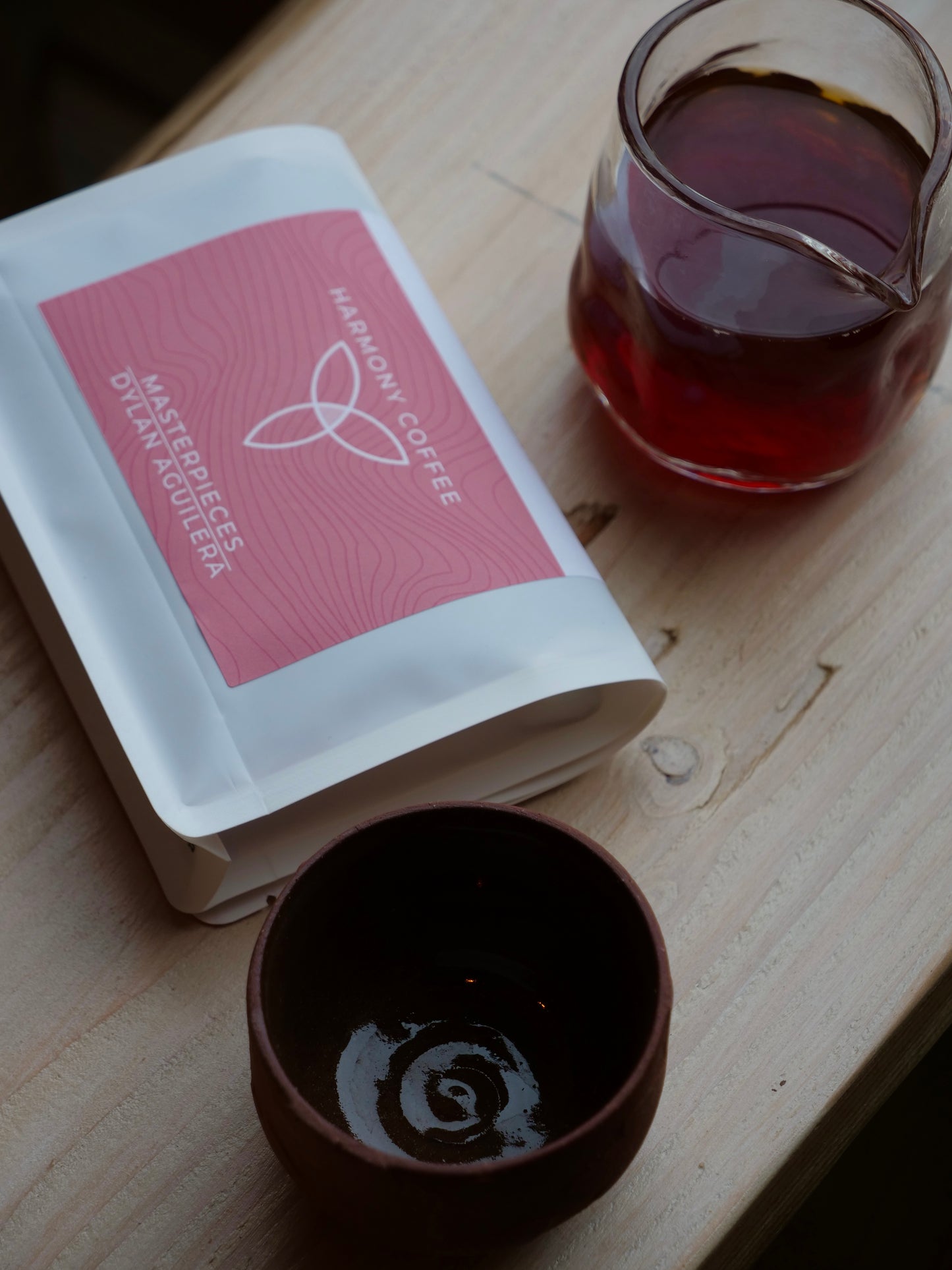 Harmony Coffee package with a glass and ceramic cup on a wooden surface