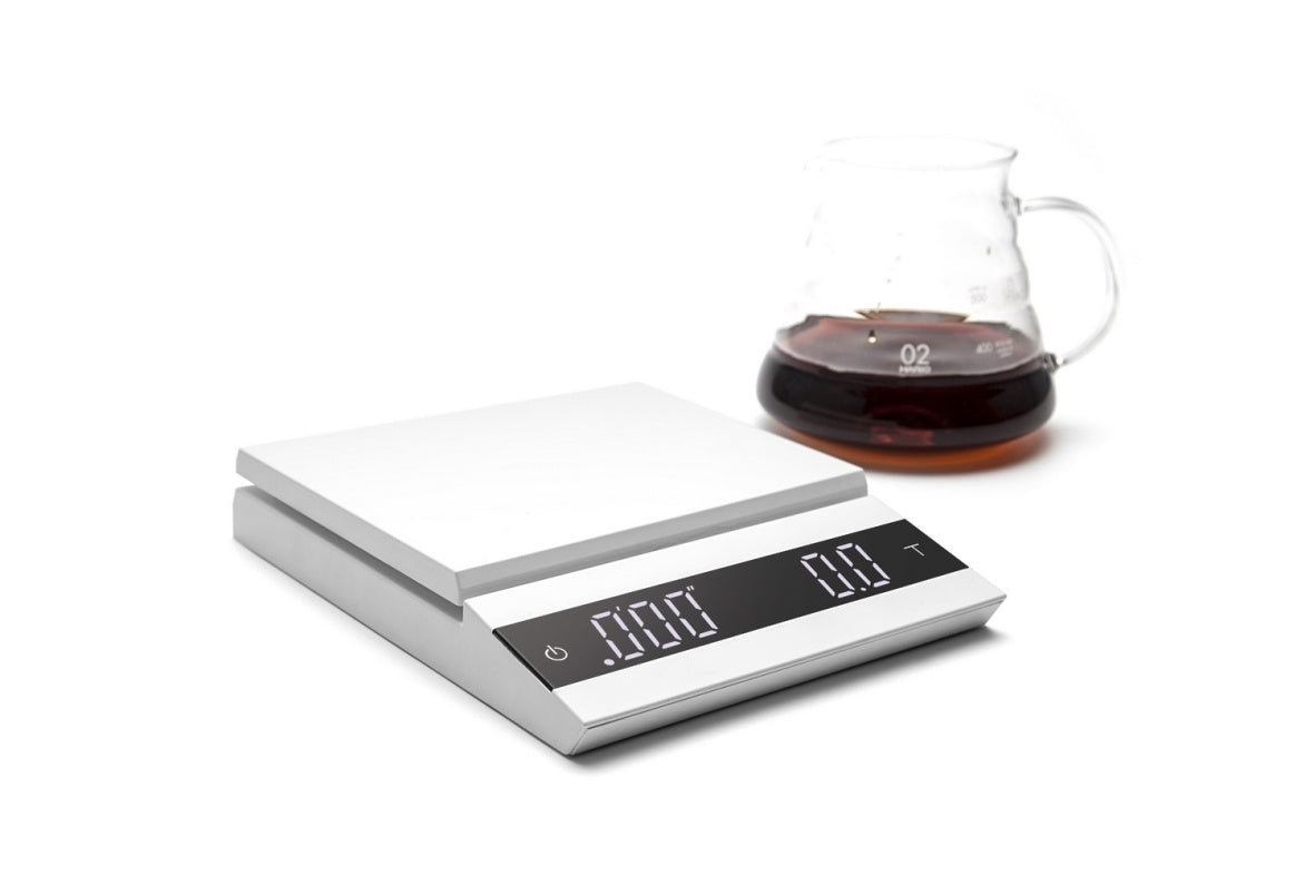 Felicita scales with a glass of coffee on a white background