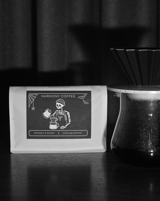 YunLan Estate Spooky & Scary Halloween coffee bag with skeleton barista label beside a pour-over brewer - Harmony Coffee York