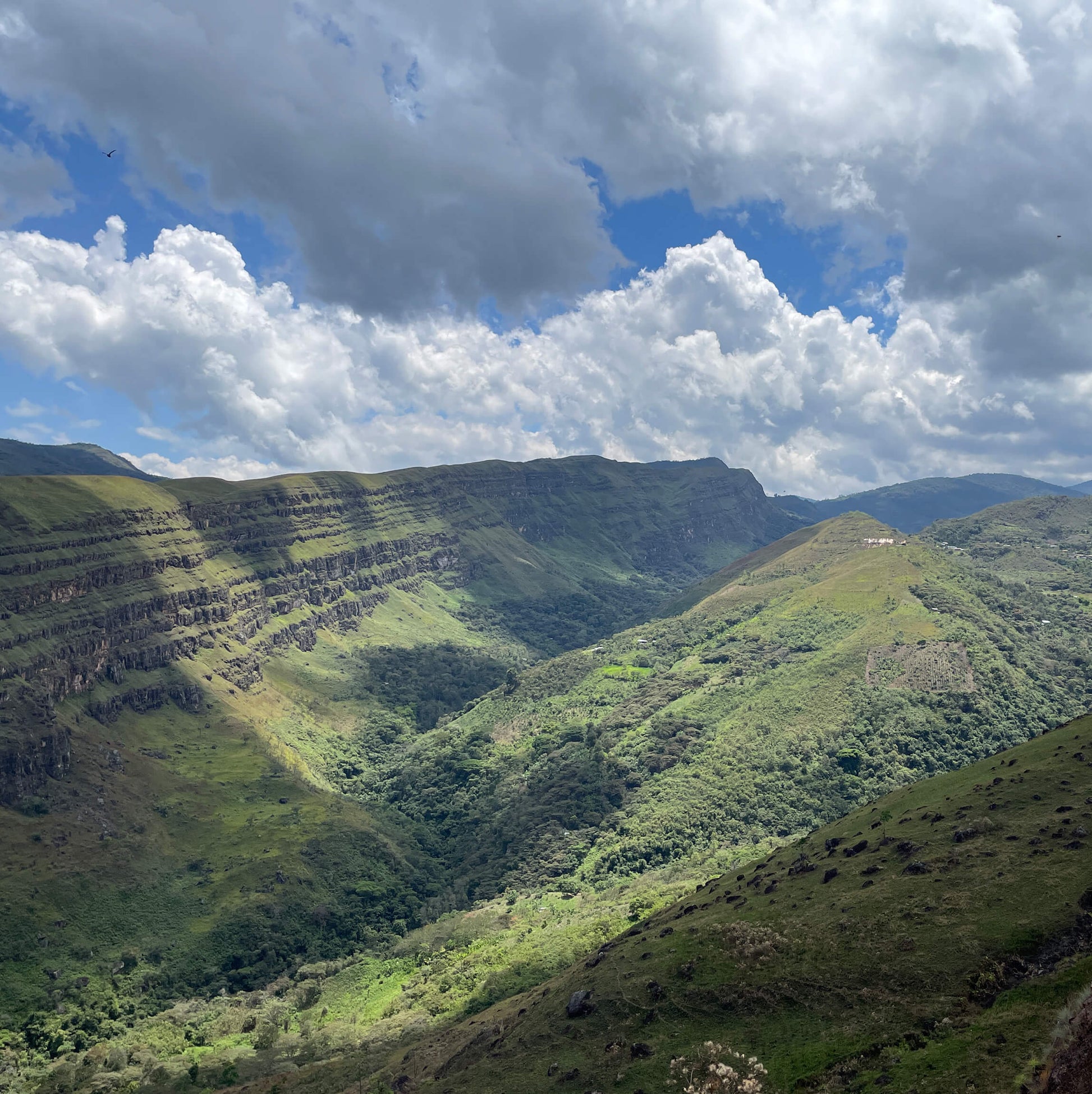 Scenic view of Peru with green mountains under a blue sky with white clouds