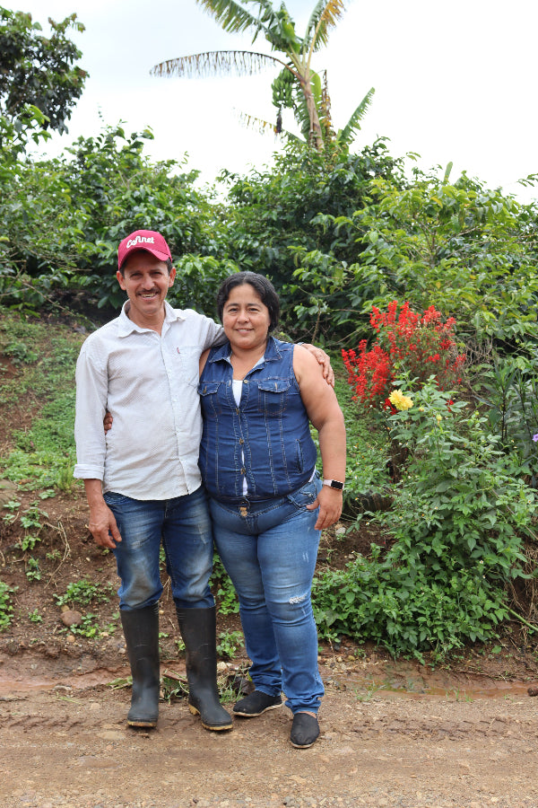 Luis Anibal standing outdoors with greenery and flowers in the background