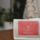 A bag of Harmony Coffee Masterpieces Manuel Marlo Gesha on a wooden table, with a coral label and white wavy line art