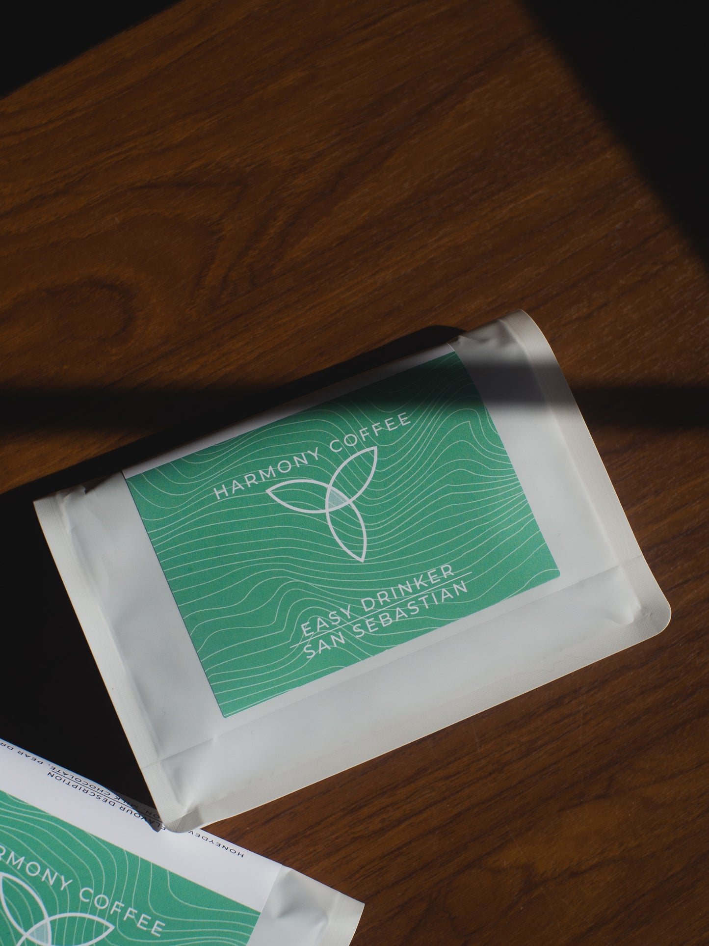 Two packets of San Sebastián from Harmony Coffee on a wooden surface