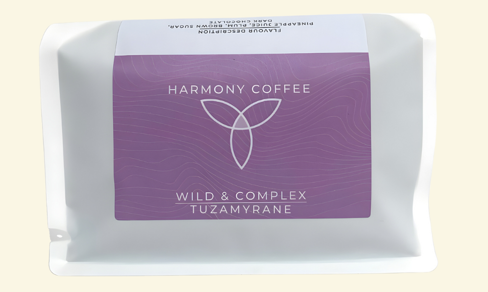 Harmony Coffee package with purple label on a light beige background. Tuzamyrane from Rwanda.