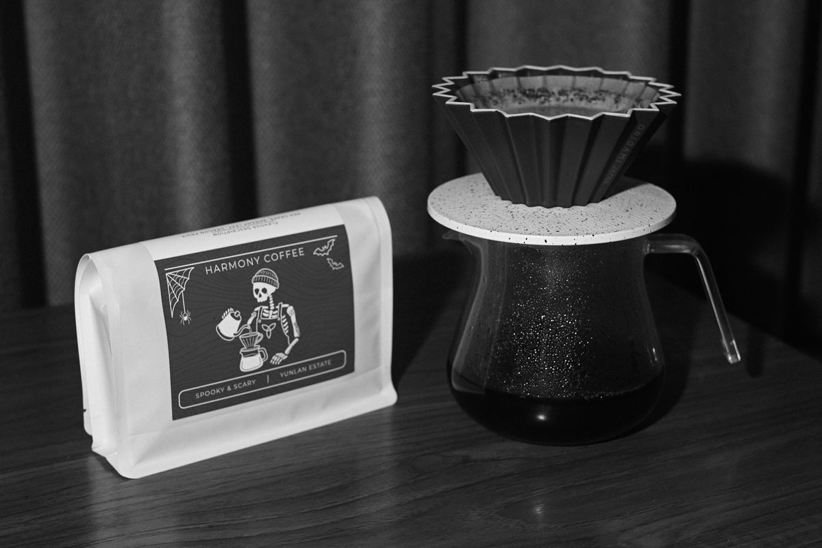 YunLan Estate natural Chinese coffee bag next to an origami dripper on a glass server of brewed coffee