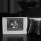 YunLan Estate Spooky & Scary Halloween coffee bag with skeleton barista label beside a pour-over brewer - Harmony Coffee York