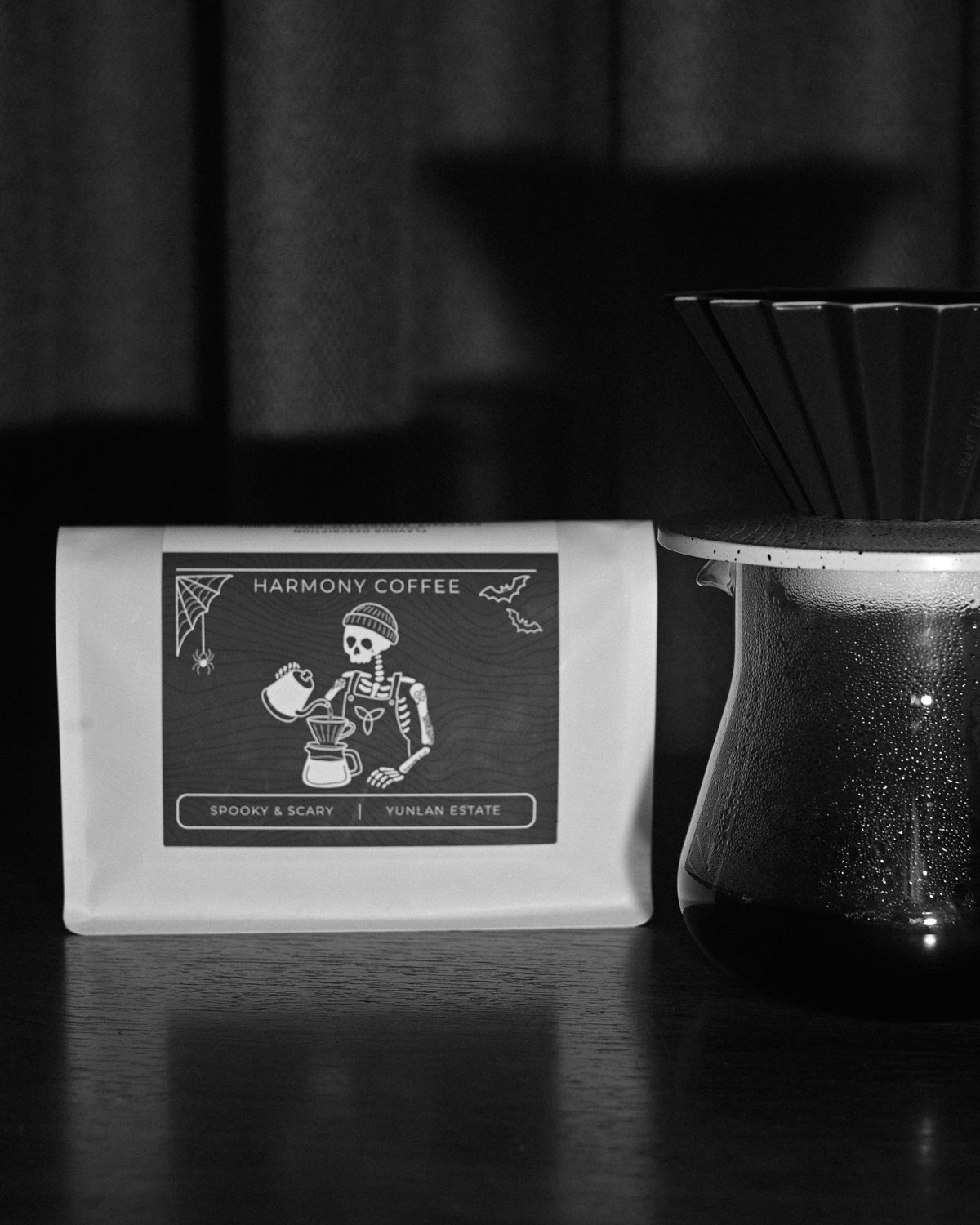 YunLan Estate Spooky & Scary Halloween coffee bag with skeleton barista label beside a pour-over brewer - Harmony Coffee York